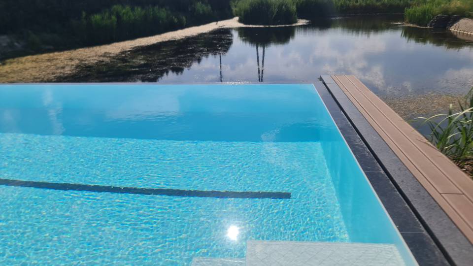 Designerski basen z rynna przelewową. Wykończenie z kamienia naturalnego. Designerski basen z rynna przelewową. Wykończenie z kamienia naturalnego.