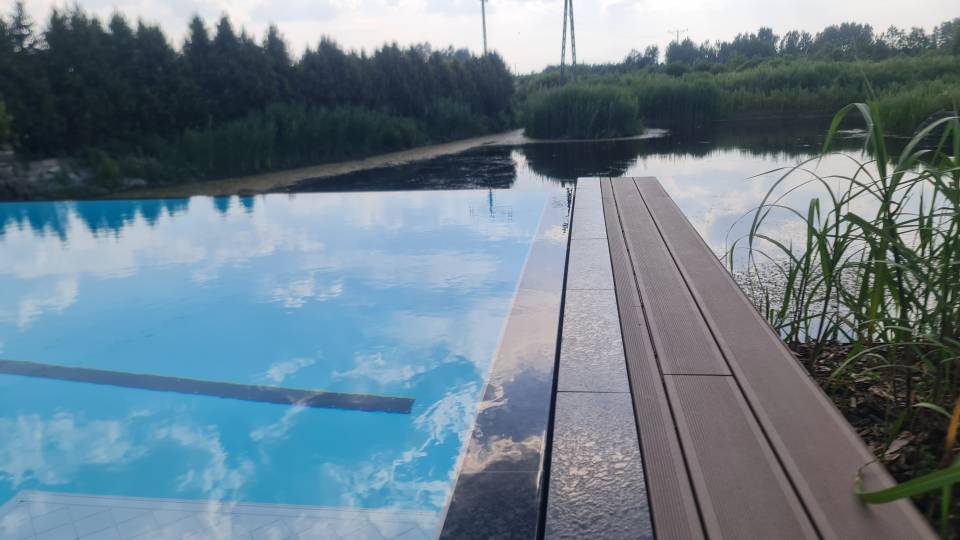 Designerski basen z rynna przelewową. Wykończenie z kamienia naturalnego. Designerski basen z rynna przelewową. Wykończenie z kamienia naturalnego.